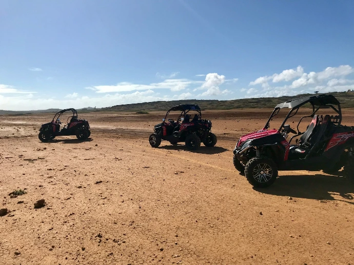 black and red atv on brown sand under blue sky during daytime